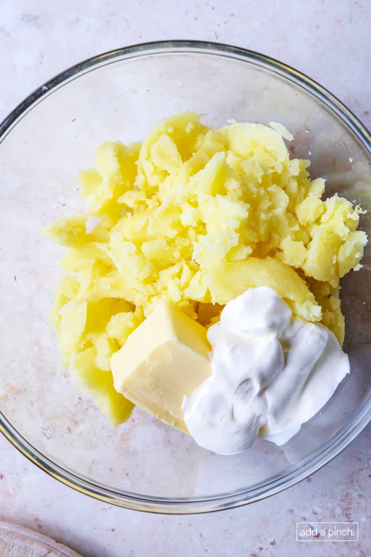 Potato filling with butter sour cream in a mixxing bowl prior to mixing.