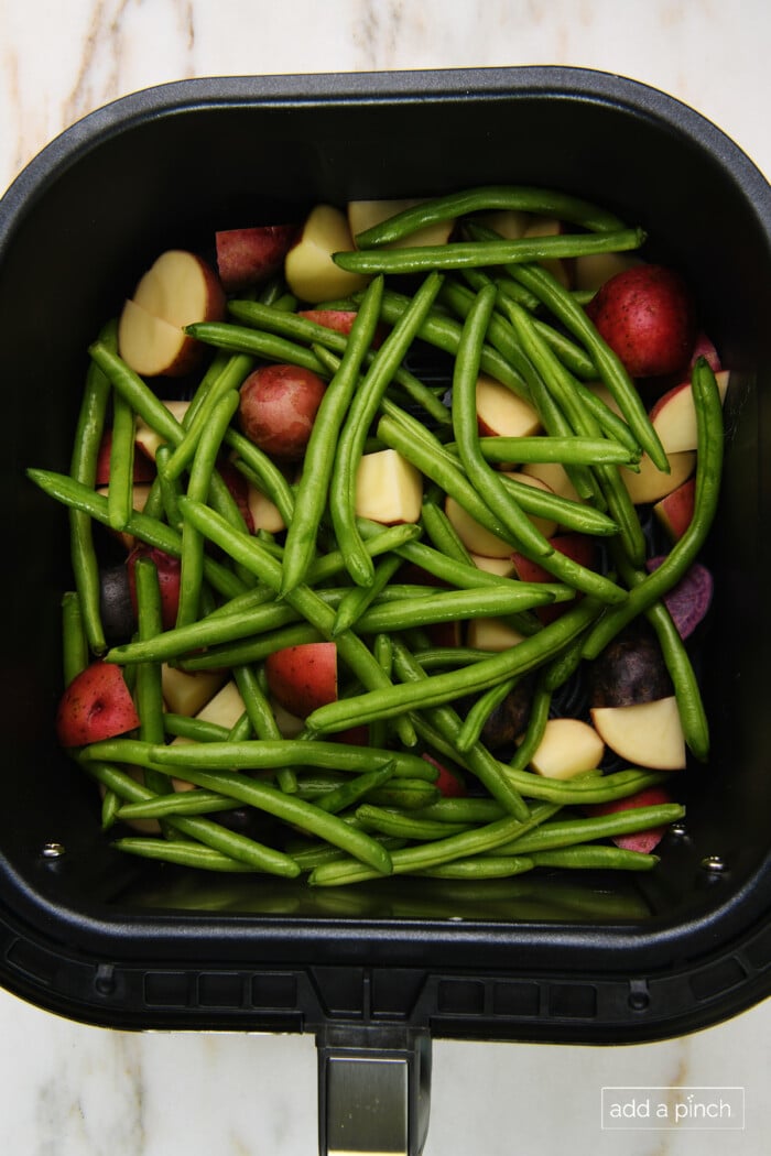 Green beans and potatoes in air fryer basket