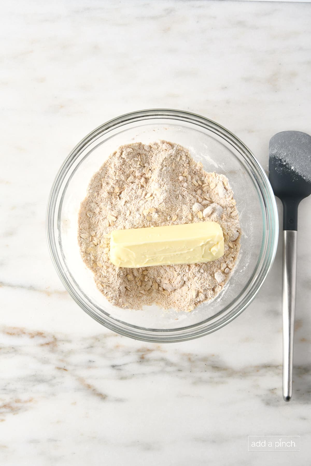 Glass bowl with flour, oats, brown sugar, softened butter, and other ingredients to make   oat streusel topping for apple crisp.