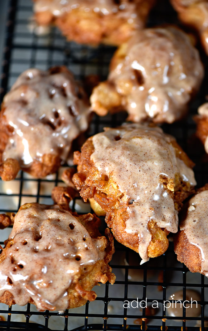 Glazed Apple fritters on a cooling rack // addapinch.com