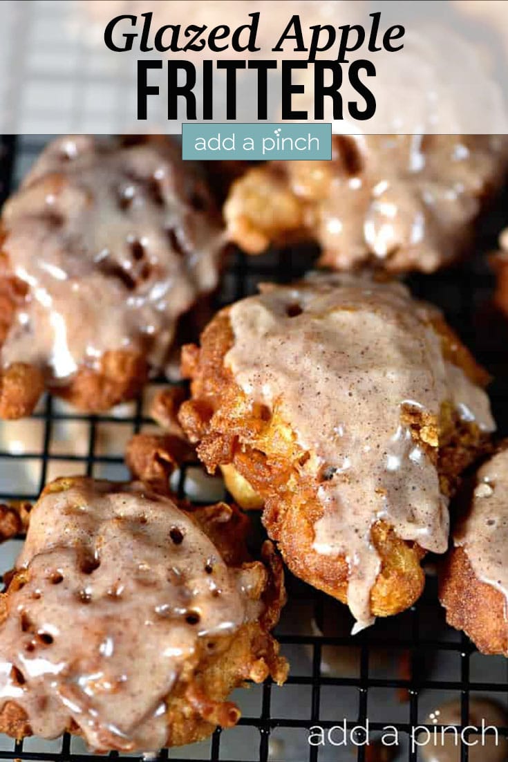 Tray of golden brown Apple Fritters drizzled with glaze - with text - addapinch.com
