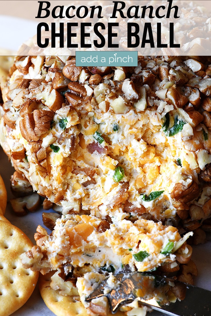 Bacon Ranch Cheese Ball on serving dish with crackers and knife - with text - addapinch.com
