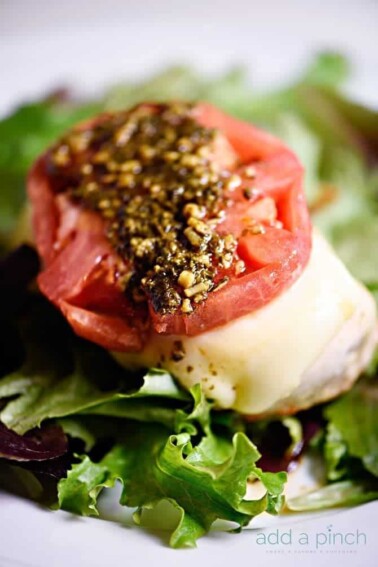 Chicken caprese makes a quick and easy meal that is always a favorite! This baked chicken caprese is made with chicken, mozzarella, tomatoes and pesto! // addapinch.com