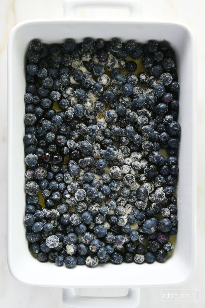 Sugared blueberries in a white baking dish.