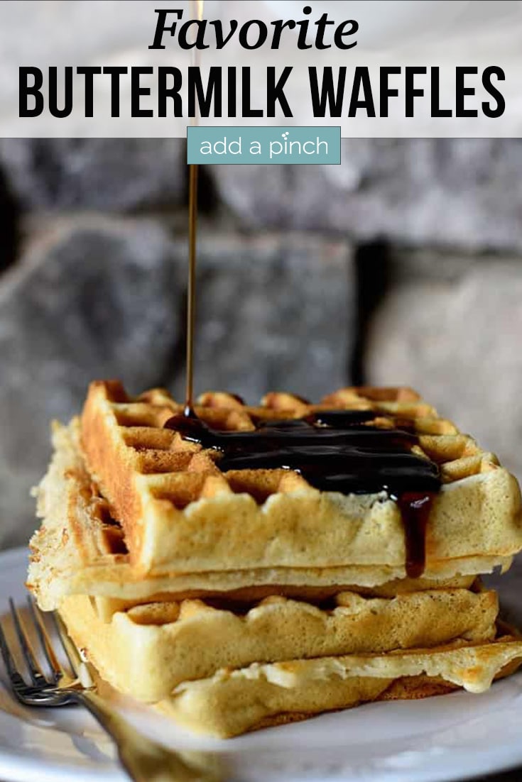 Stack of Our Favorite Buttermilk Waffles being drizzled with syrup - with text - addapinch.com