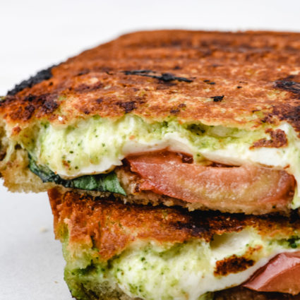 Closeup of caprese grilled cheese sandwich sliced in half // addapinch.com