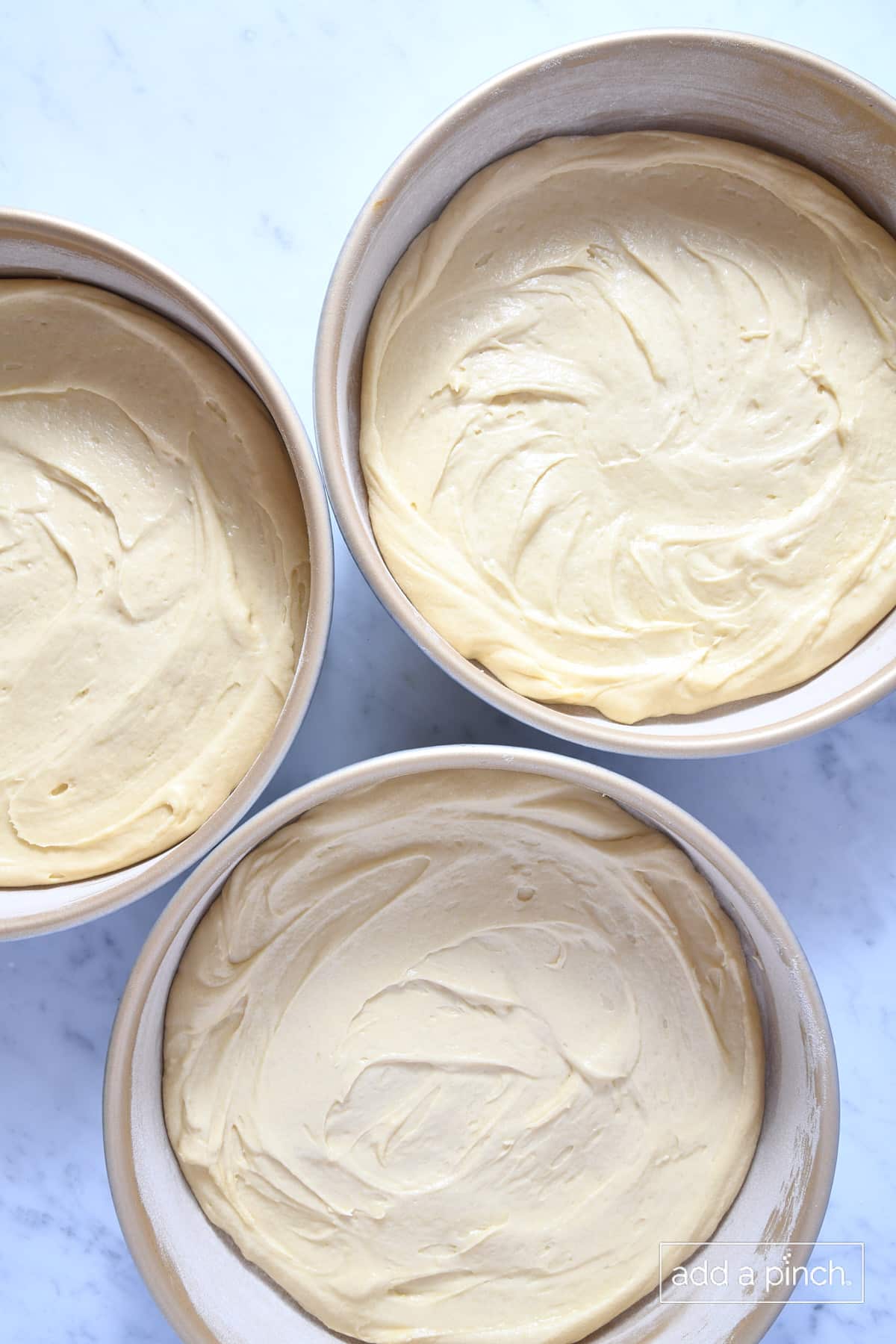 Caramel cake batter in cake pans ready to be baked.