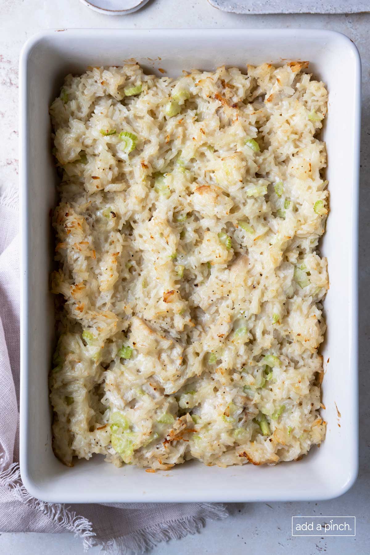 Baked chicken casserole in a white baking dish.