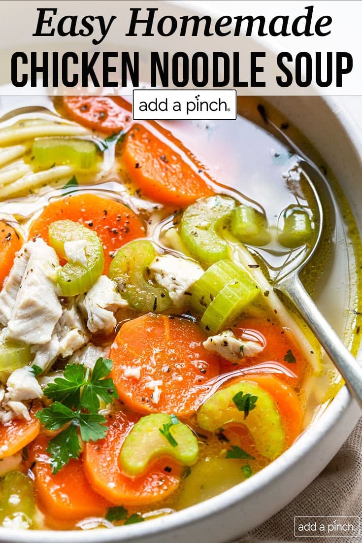 Bowl of chicken noodle soup with carrots, celery, chicken and herbs - with text - addapinch.com