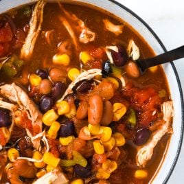 Chicken Taco Soup Recipe - So quick and easy, this chicken taco soup recipe is flavorful and delicious! Made with chicken, beans, corn, it is on the table in less than 30 minutes! // addapinch.com