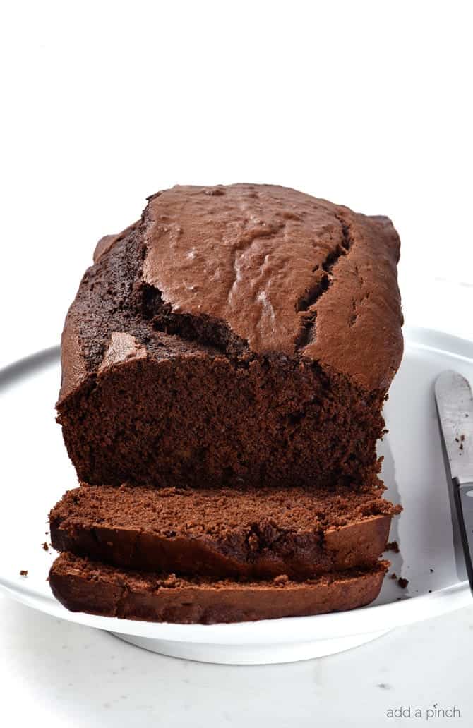 Chocolate Banana Bread partially sliced on white serving tray // addapinch.com