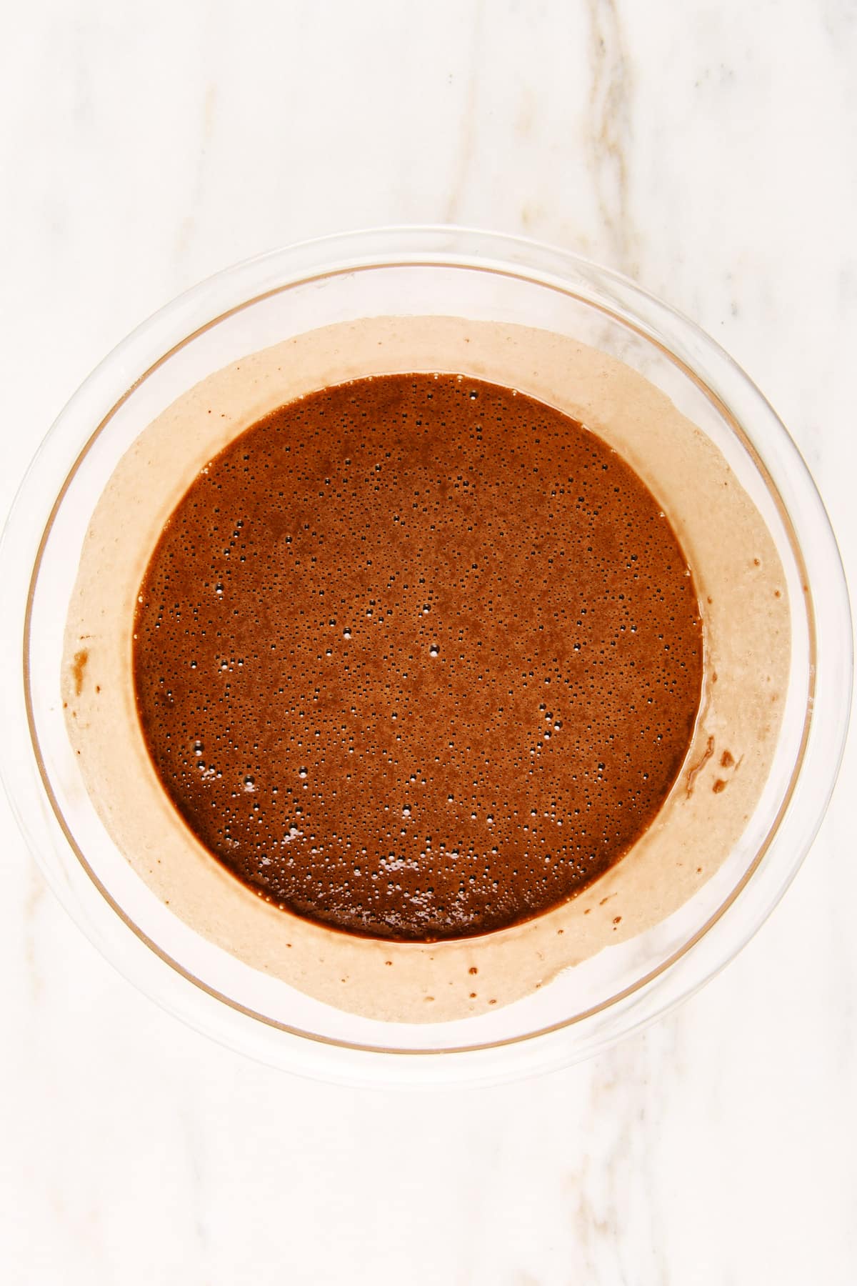 Chocolate loaf cake batter in a glass mixing bowl.