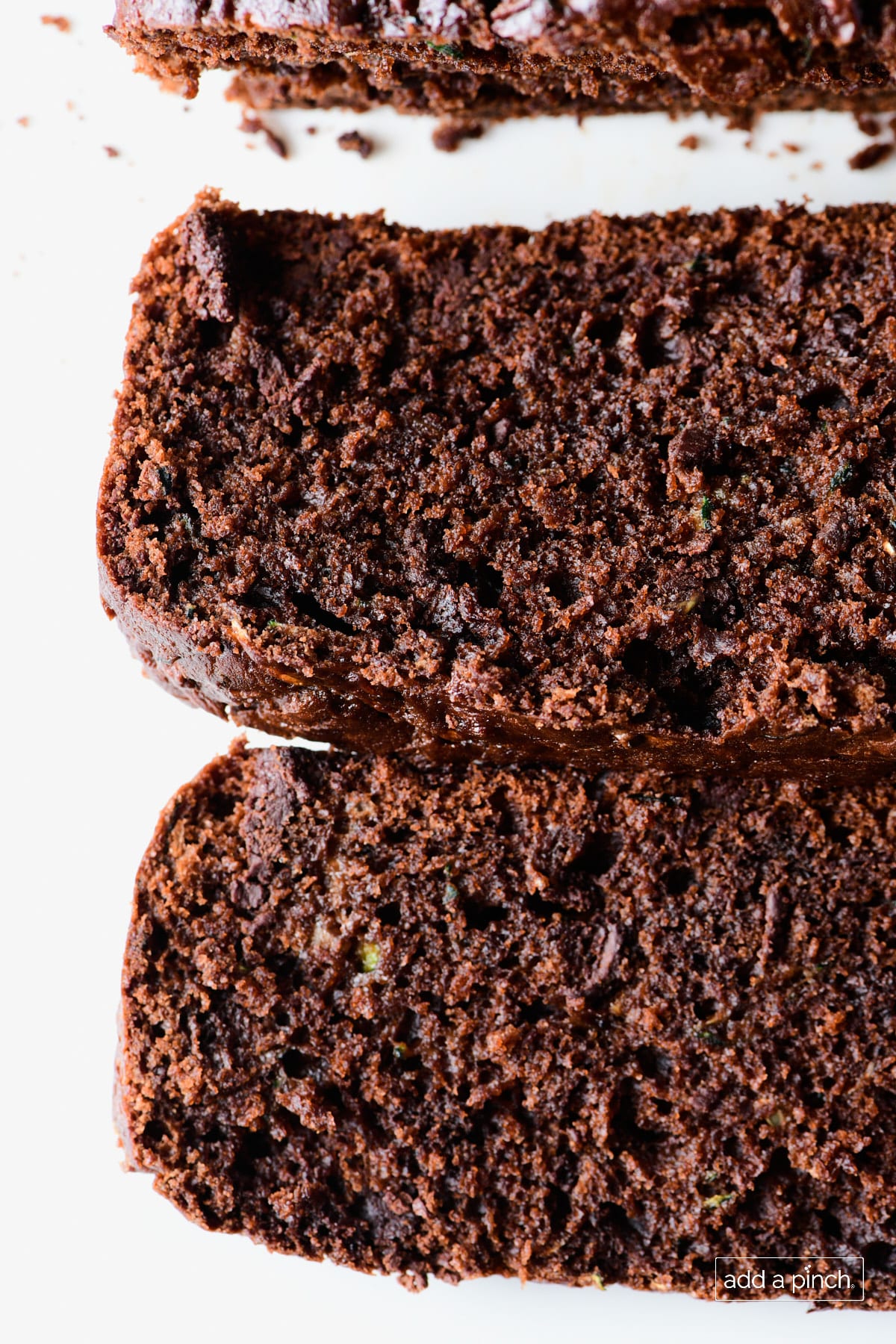 Slices of chocolate zucchini bread on a white plate.