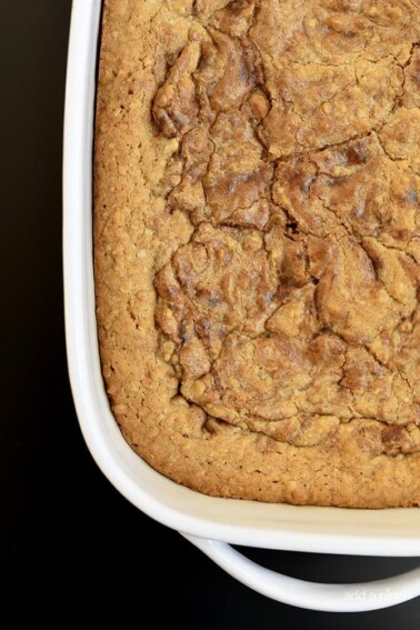 White baking dish with baked blondies on a dark surface.
