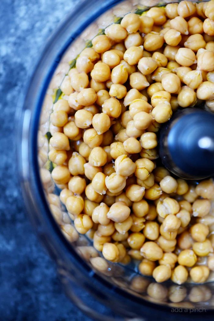 Chickpeas in a food processor container on a stone countertop // addapinch.com