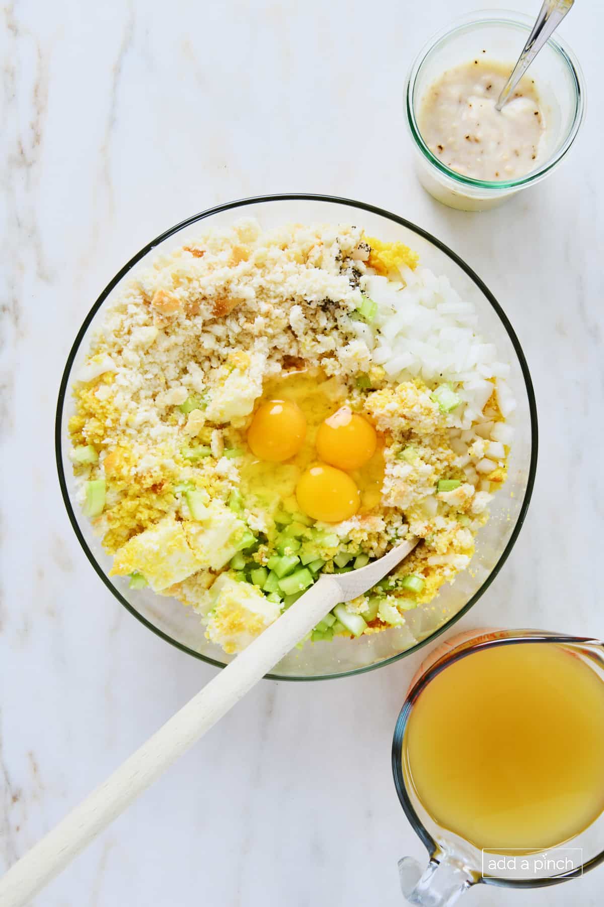 Eggs added to the glass bowl for making cornbread dressing.