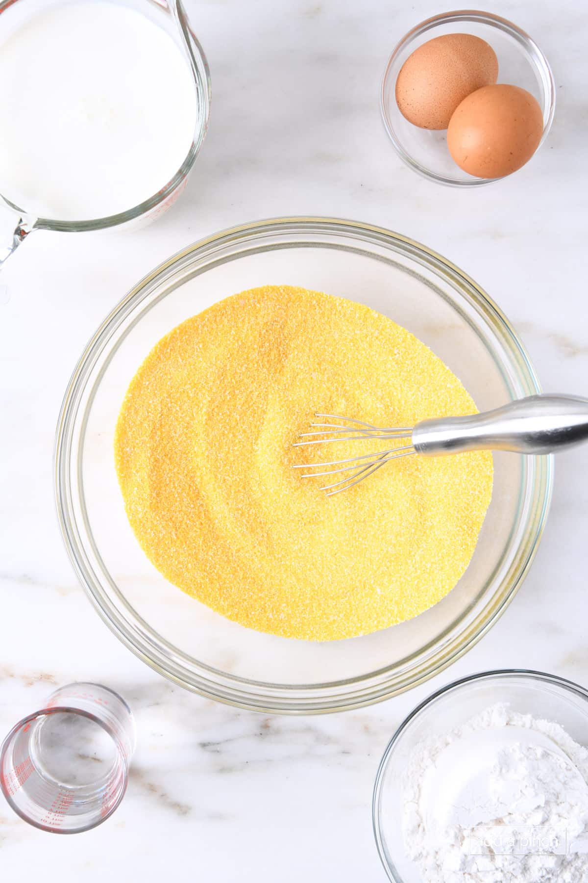 Ingredients to make Southern cornbread on a marble countertop.