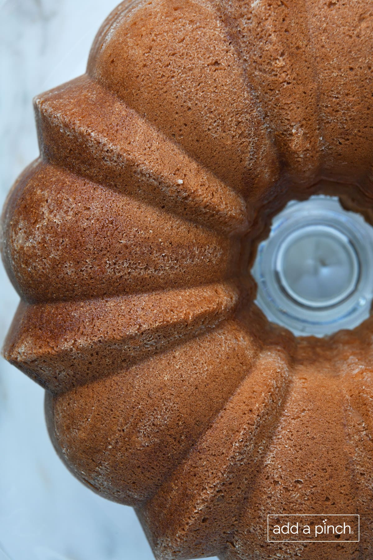Top view of a golden brown cream cheese pound cake baked in a Bundt pan. 