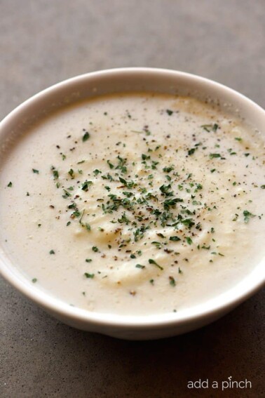 Creamy Cauliflower Soup Recipe - Creamy Cauliflower Soup makes a delicious and comforting soup recipe without a drop of cream! The garlic, onion, and cauliflower are blended together to create a dairy-free, creamy cauliflower soup recipe that everyone loves! // addapinch.com