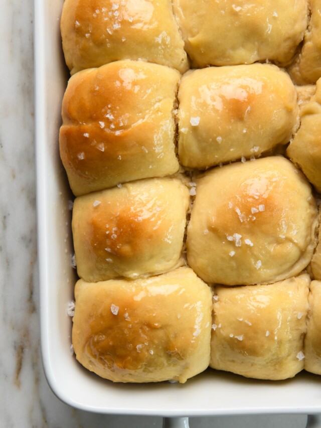 Baked dinner rolls brushed with butter and sprinkled with salt.