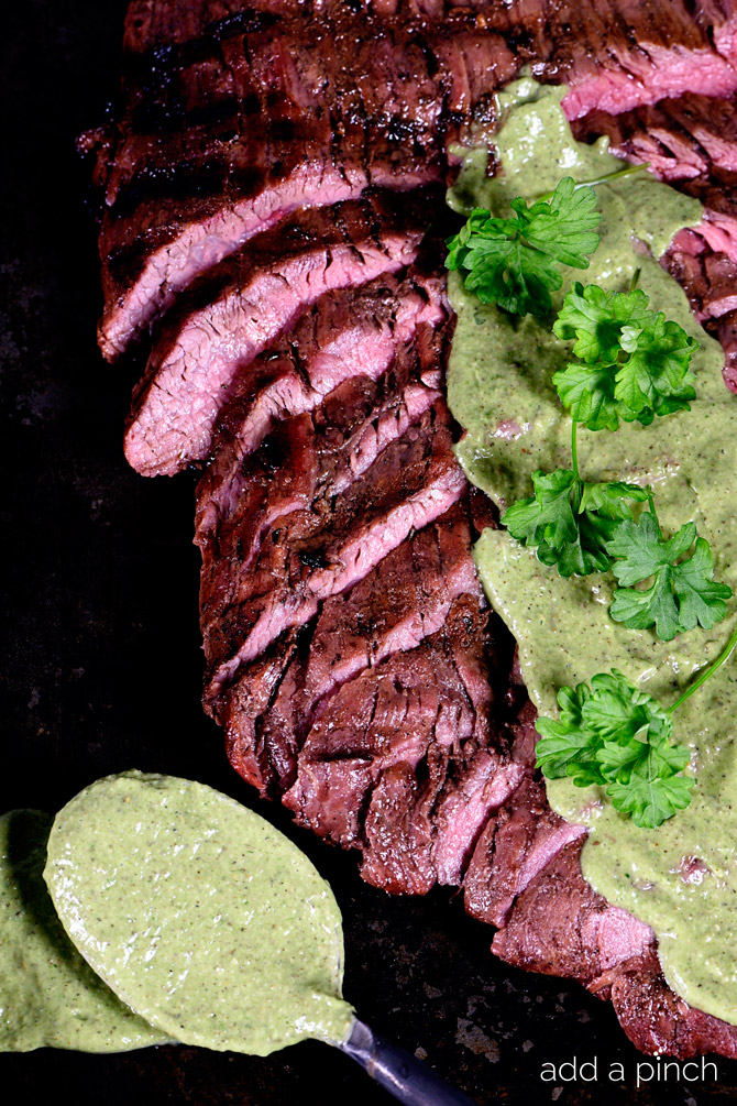 Grilled Flank Steak sliced and served with a chimichurri sauce. // addapinch.com