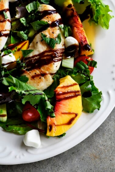 Grilled Chicken and Peach Salad Recipe - A light and delicious dish  that is perfect for lunch or dinner. Made with grilled chicken, fresh juicy peaches, and topped with tangy balsamic. // addapinch.com