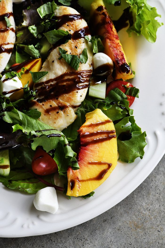 Grilled Chicken and Peach Salad Recipe - A light and delicious dishย that is perfect for lunch or dinner. Made with grilled chicken, fresh juicy peaches, and topped with tangy balsamic. // addapinch.com