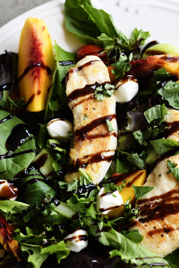 Grilled Chicken and Peach Salad Recipe - A light and delicious dish  that is perfect for lunch or dinner. Made with grilled chicken, fresh juicy peaches, and topped with tangy balsamic. // addapinch.com