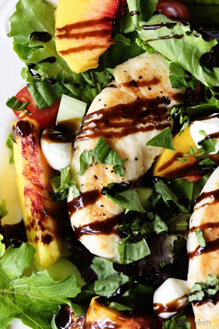 Grilled Chicken and Peach Salad Recipe - A light and delicious dish  that is perfect for lunch or dinner. Made with grilled chicken, fresh juicy peaches, and topped with tangy balsamic. // addapinch.com