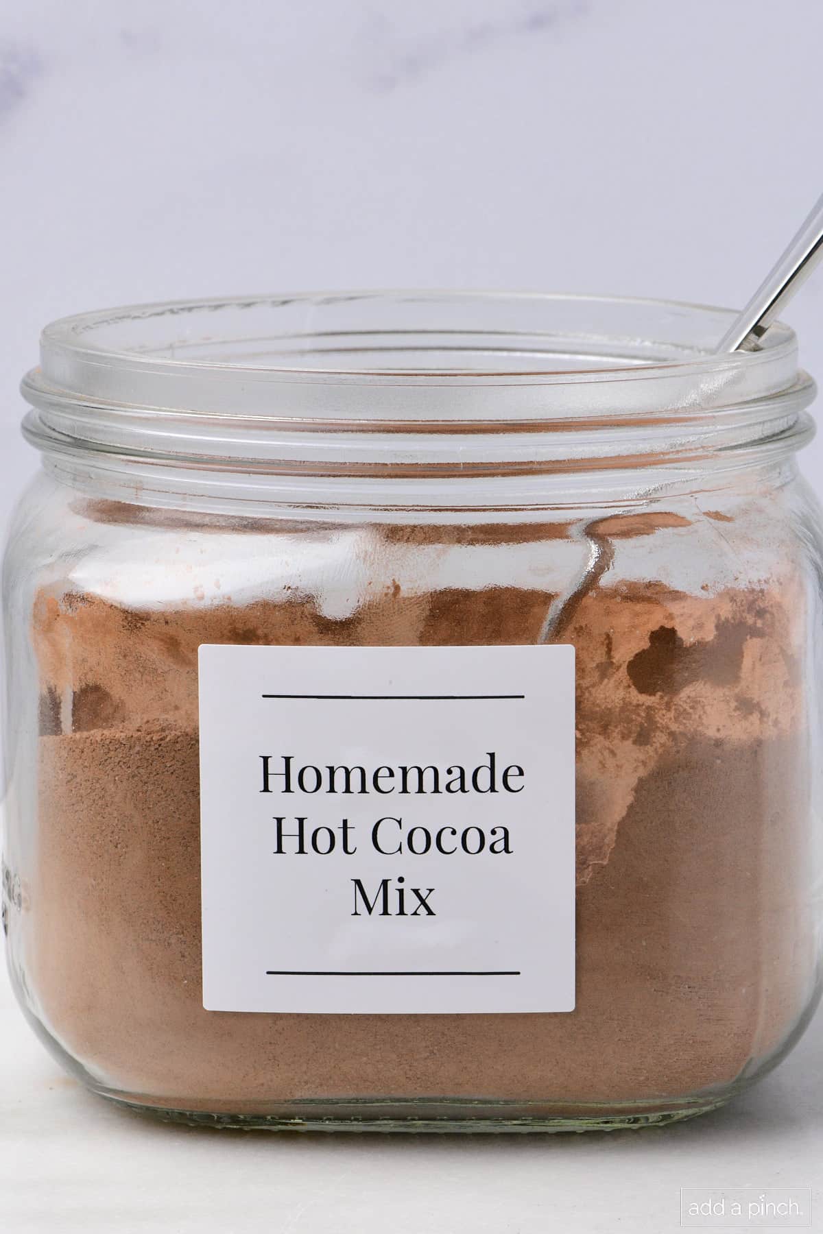 Homemade hot cocoa mix in a glass jar with a label.