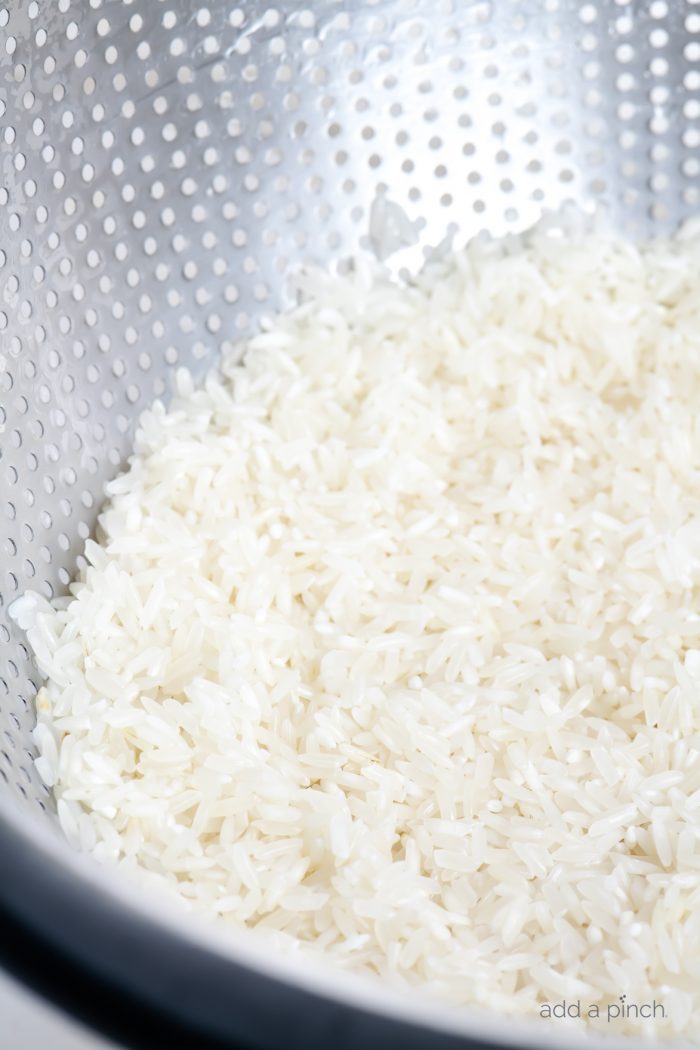 Uncooked white rice in a colander. // addapinch.com