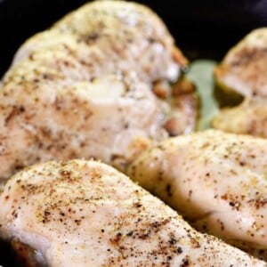 Cooked chicken seasoned and cooling in a black dish.