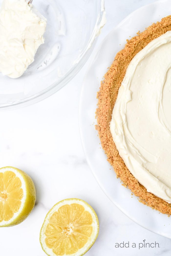 This no bake lemon cream pie is a quick and easy twist on the classic. Made with cream cheese, cream, and lots of lemon with a buttery graham cracker crust. // addapinch.com