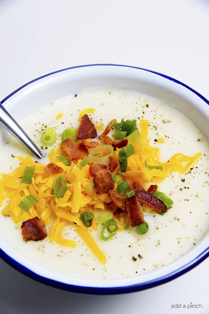 Loaded Baked Potato Soup Recipe - Loaded baked potato soup makes a warm, comforting potato soup recipe. Made with baked potatoes blended into a creamy soup and topped with your potato bar favorites! // addapinch.com
