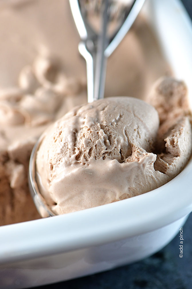 Scoop of creamy Chocolate Ice Cream from a white container // addapinch.com