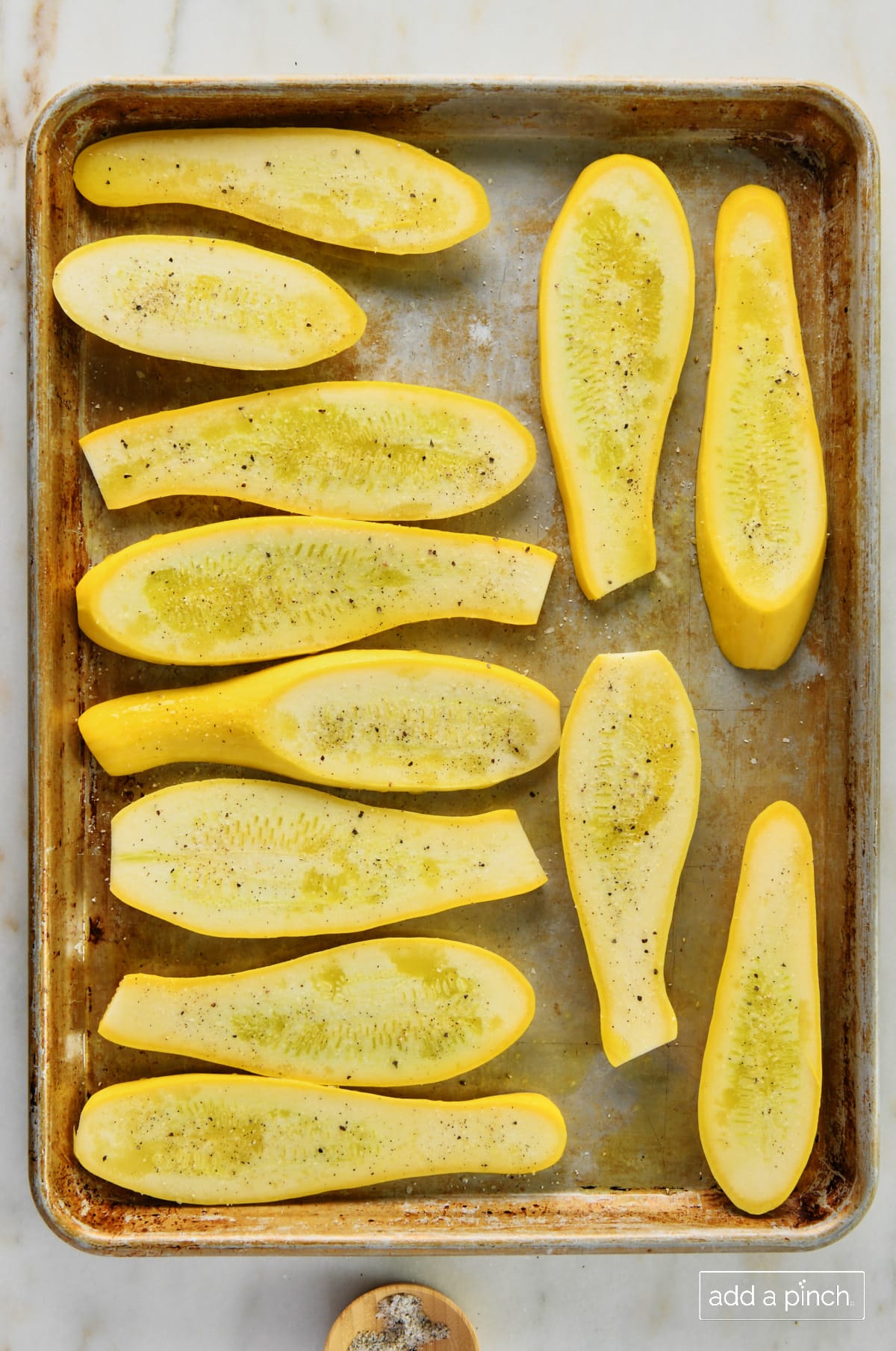 Photo of squash with Stone House Seasoning on a baking sheet pan.