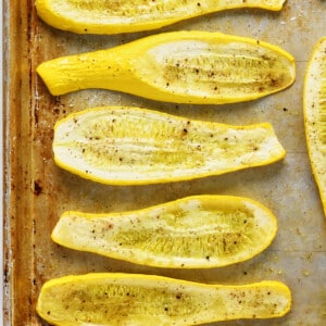 Roasted squash on a baking sheet on a marble surface.