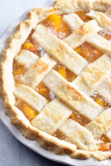 Classic Peach Pie Recipe - This Classic Peach Pie Recipe is a summer staple! Made with a lattice-topped double crust and filled with delicious peaches! // addapinch.com
