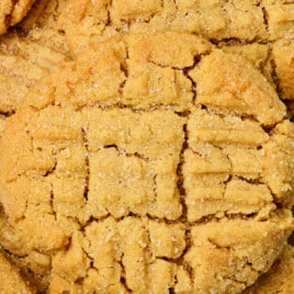 Closeup of baked peanut butter cookie with criss cross pattern on top.