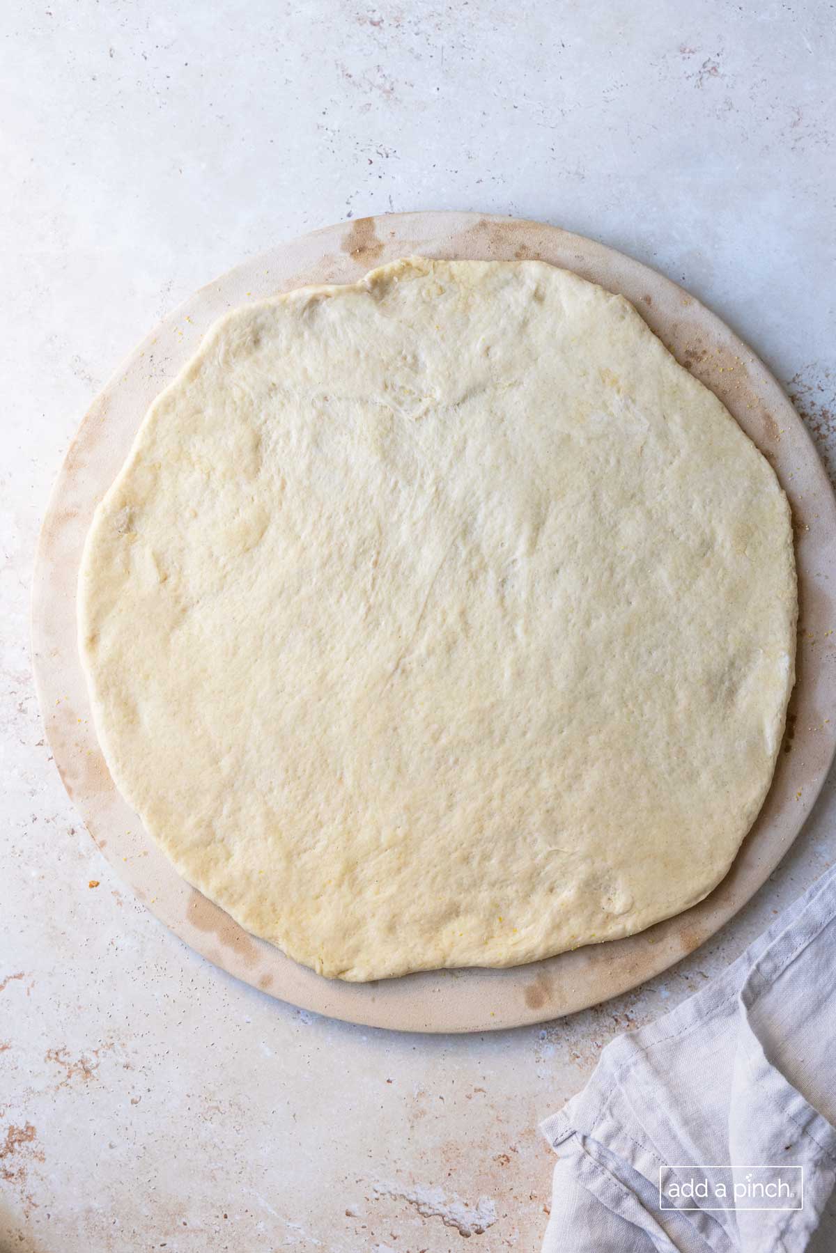 Pizza dough on a pizza stone.
