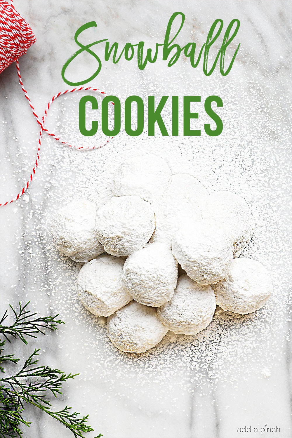 Stack of Snowball Cookies on marble board surrounded by ribbon and greenery - with text - addapinch.com