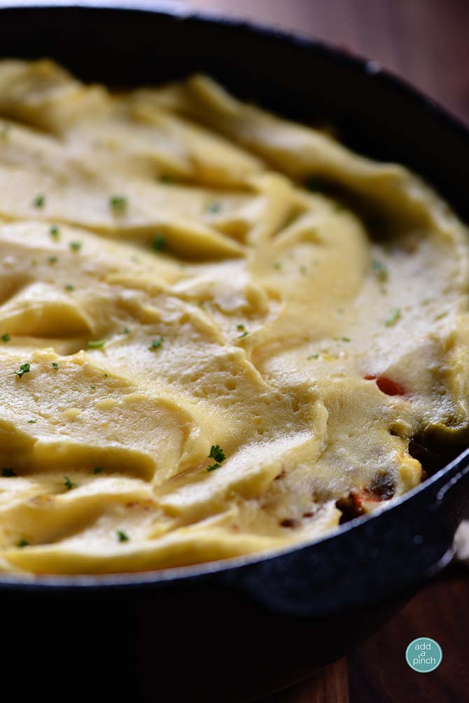 Cheesy mashed potato topping over Shepherd's Pie in a large skillet // addapinch.com