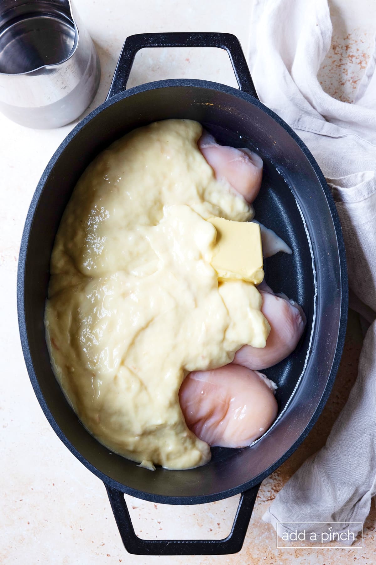 Chicken, butter, cream of chicken soup, and water added to slow cooker insert.