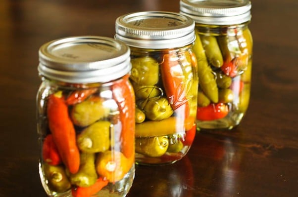 Canning jars of Southern Pepper Sauce with green and red peppers.