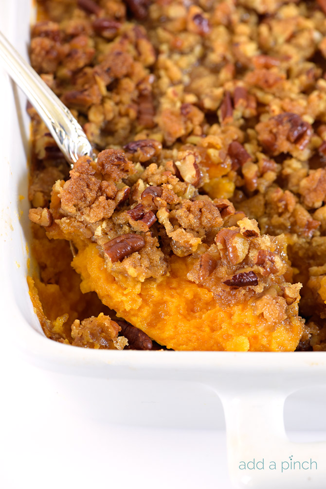Sweet Potato Casserole with pecan streusel topping in white baking dish.