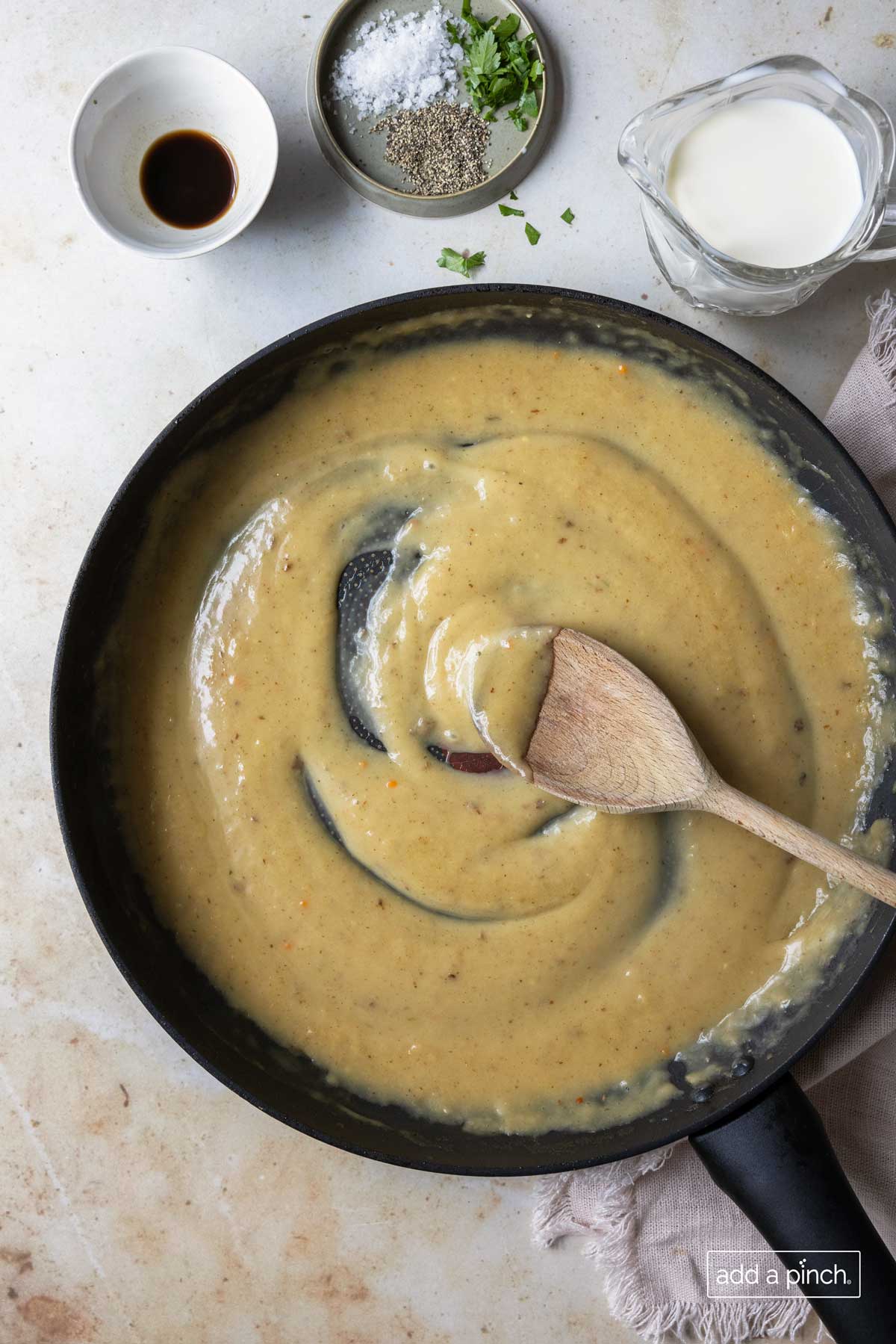 Skillet holds a brown gravy alongside other swedish meatball sauce ingredients.