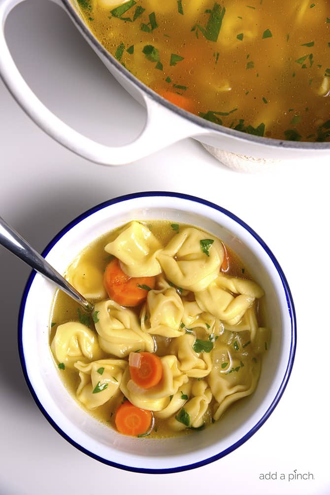 Tortellini Soup is perfect for busy nights! Made with vegetables, cheesy tortellini and topped with fresh parmesan! Ready and on the table in 30 minutes! // addapinch.com