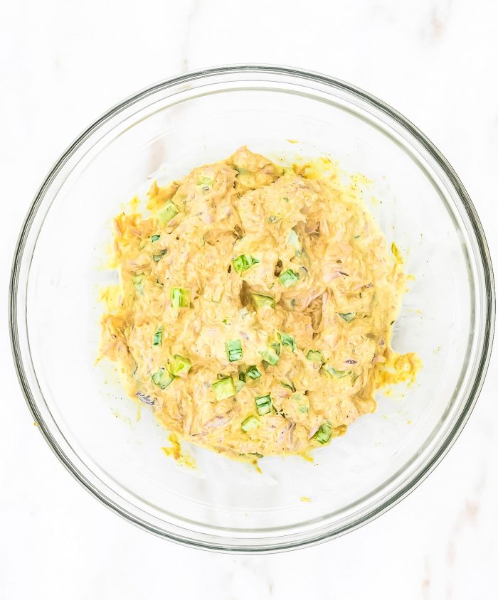 Clear glass bowl with mixed tuna salad on marble countertop // addapinch.com