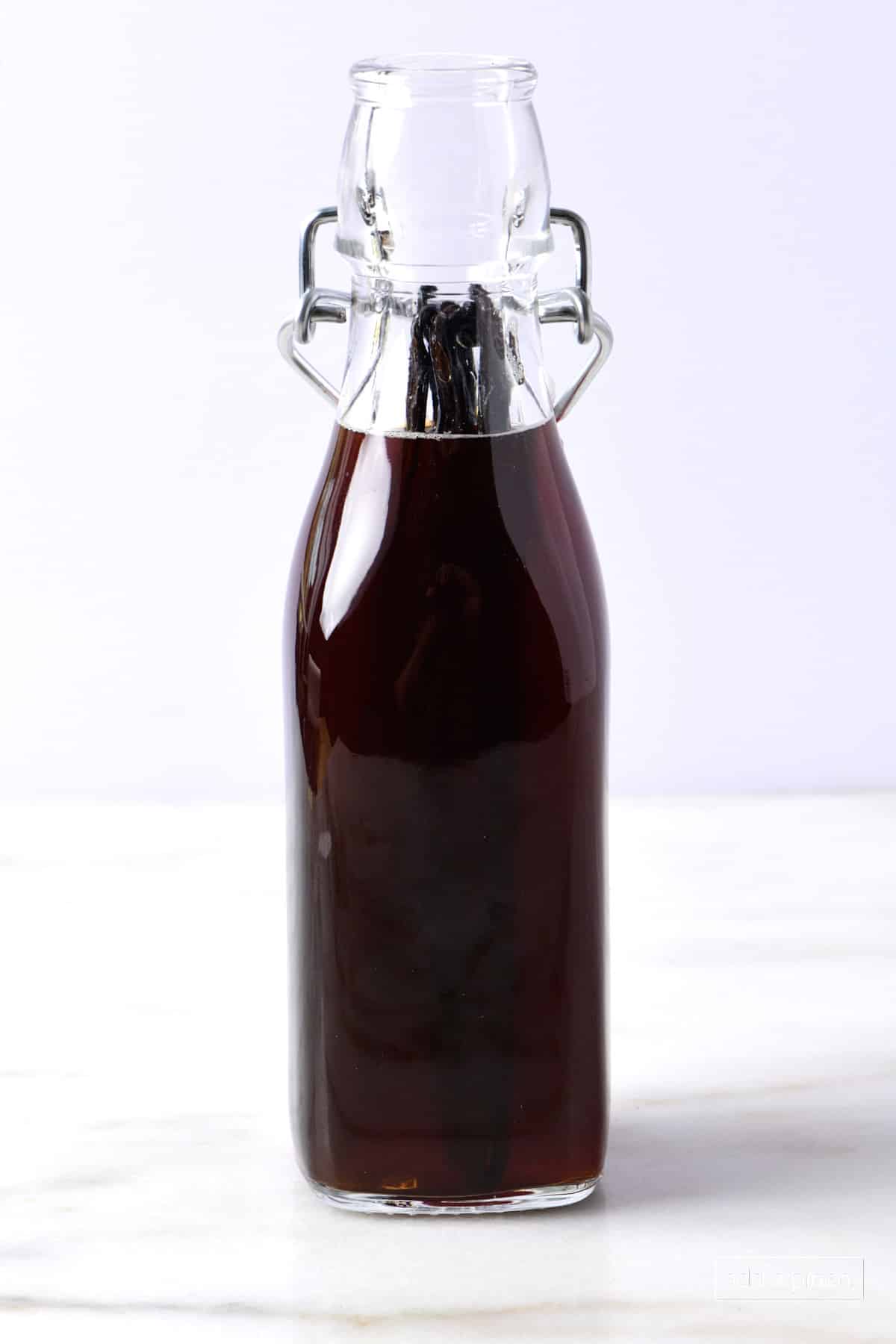 Bottle of vanilla extract on a marble surface.