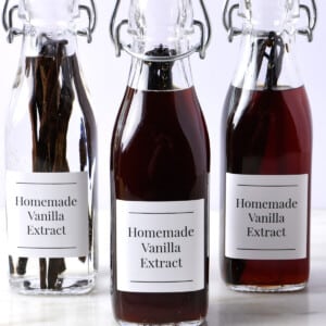 Homemade vanilla extract in different stages in swing top bottles.